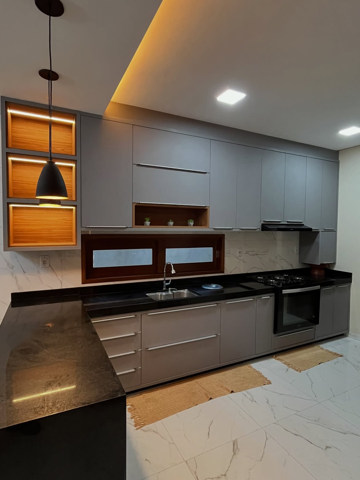 Cozinha real produzida pela Marcenart em MDF cinza, madeira e bancada preta